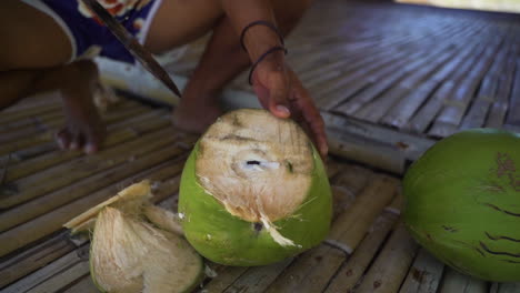 man chopping coconut with machete in slow motion