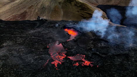 static aerial shot of the hot lava, magma and ashes coming out of mouth of the crater in fagradalsfjall, iceland