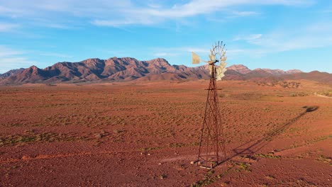 slow smooth reverse shot of windmill, desert and flinders ranges mountains, south australia