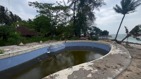 piscina en ruinas abandonada con agua sucia junto a la playa, isla de gili air indonesia