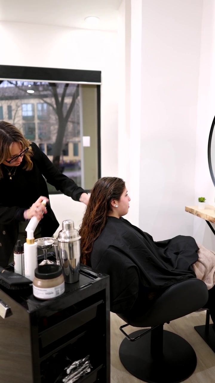Hair Stylist Spraying Product on Client's Hair in Salon