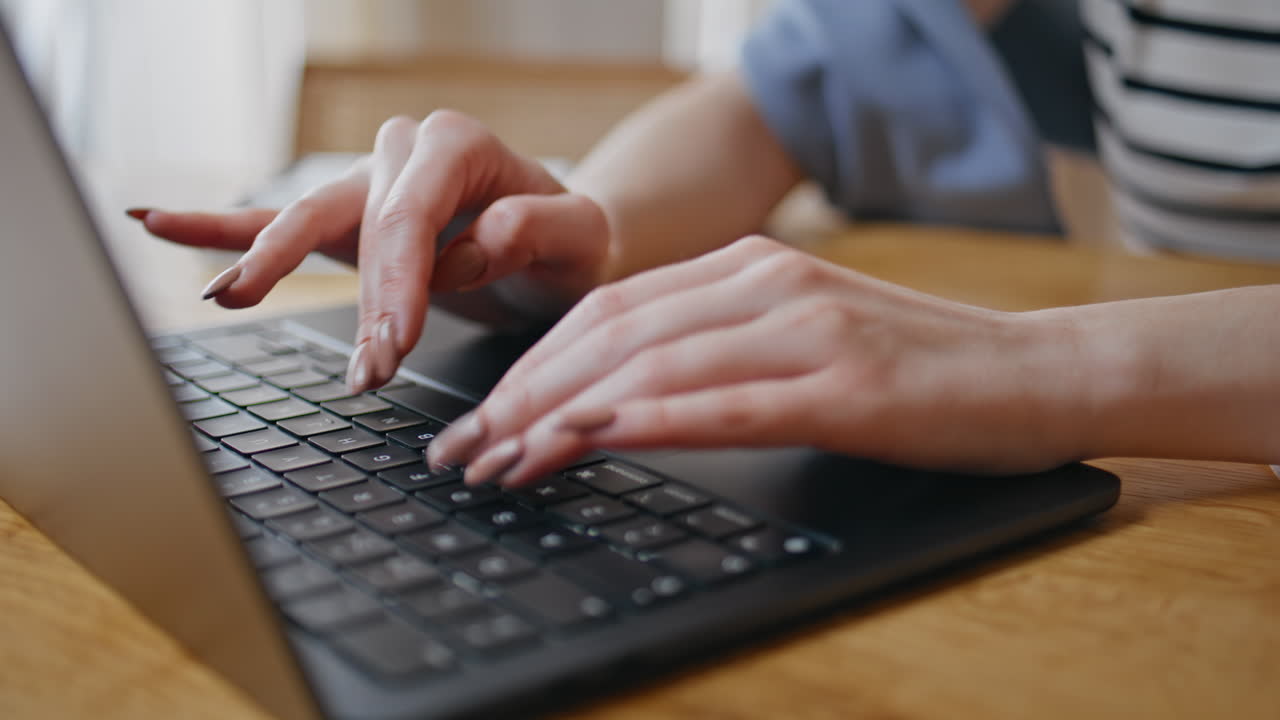 Worker hands typing keyboard laptop at wooden desk closeup. Woman working office