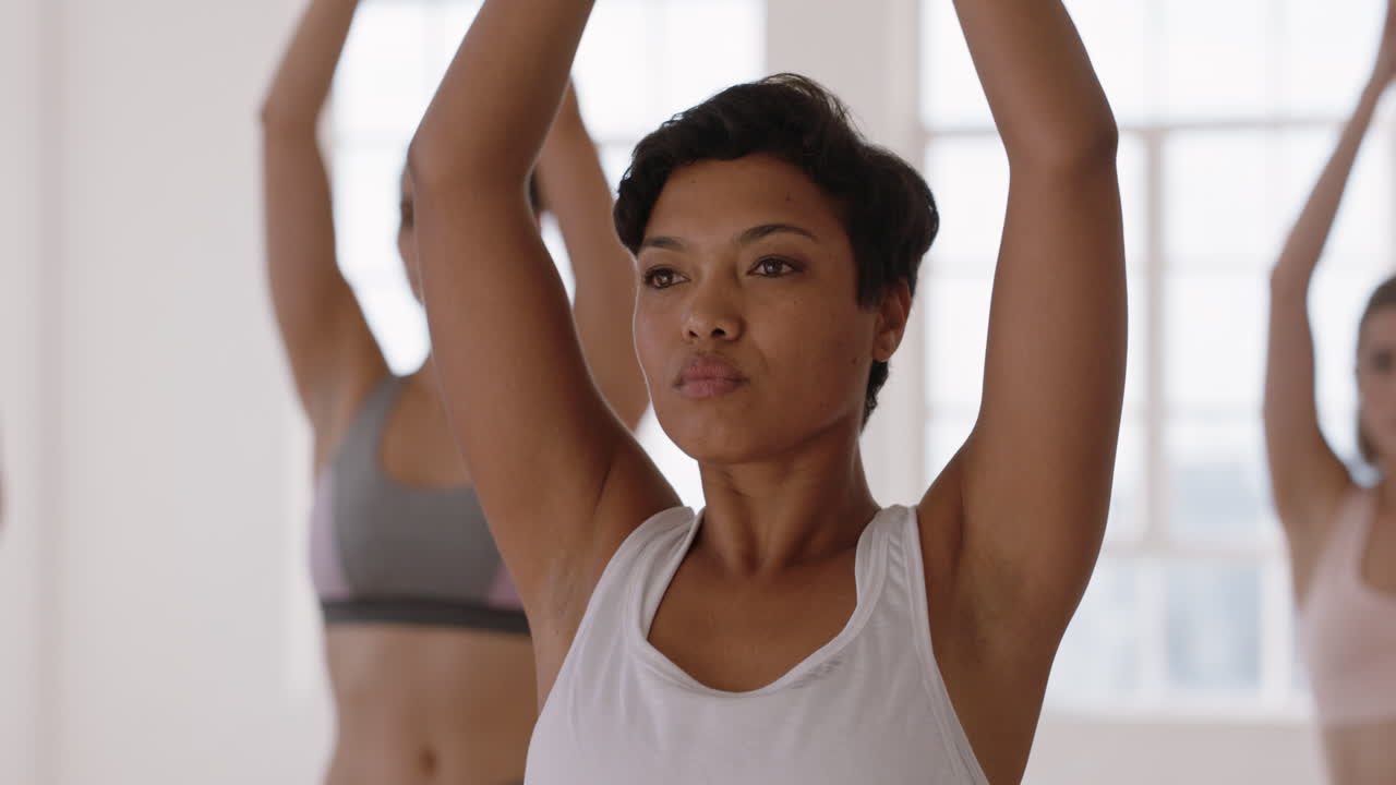 hermosa mujer de yoga practicando pose de árbol en el gimnasio entrenamiento femenino de raza mixta con instructor grupo de mujeres disfrutando de un estilo de vida saludable y equilibrado
