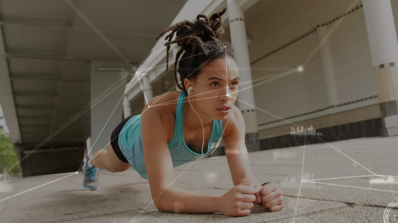 una mujer afroamericana hace plank como parte de un régimen de fitness conectado con la tecnología.