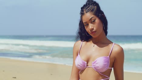 hispanic girl in a bikini close up with ocean waves in the background at a tropical beach