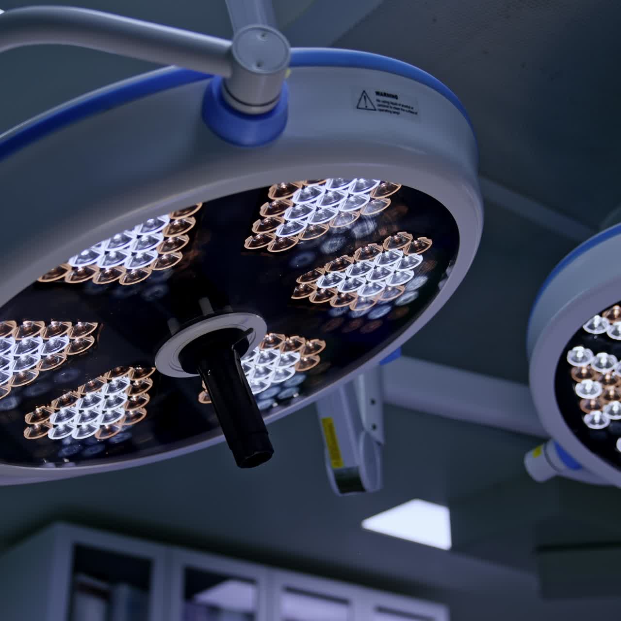 Dos grandes lámparas redondas están encendidas en la sala de operaciones. Equipo de iluminación en un quirófano moderno. Vista en ángulo bajo