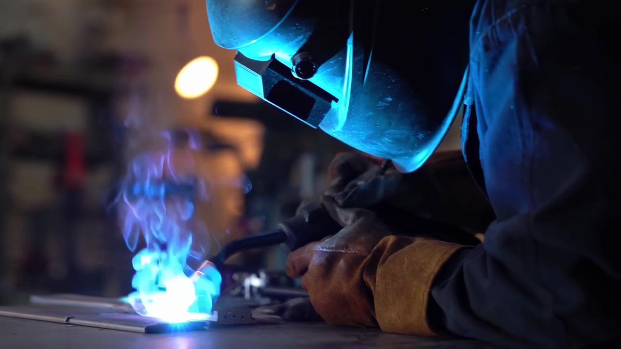 Professional Welder Working on Metal in Industrial Workshop