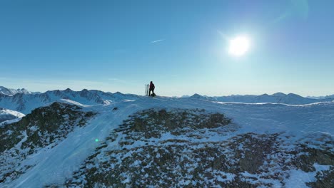 mountaineer walks towards his splitboard and enjoys the view