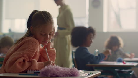 Girl-writing-test-in-classroom.-Smart-student-making-notes-in-exercise-book