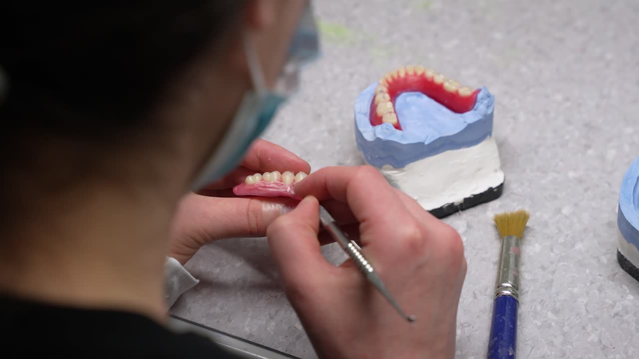 fabricación de prótesis dentales y extirpación de abolladuras en encías de cera artificial con bisturí en el puesto de trabajo por un trabajador de la salud