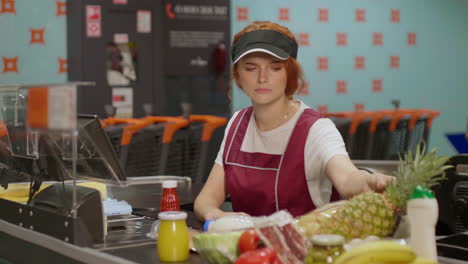 young serious sales clerk woman working in a supermarket