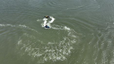 Ein-Luftbild-über-Die-Gravesend-Bay-In-Brooklyn,-Ny,-Während-Zwei-Jetskifahrer-Den-Schönen-Tag-Genießen