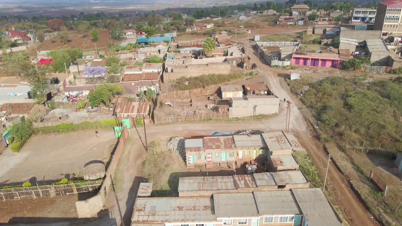 Aerial view following a settlement through a small town, in rural Africa - top down, drone shot