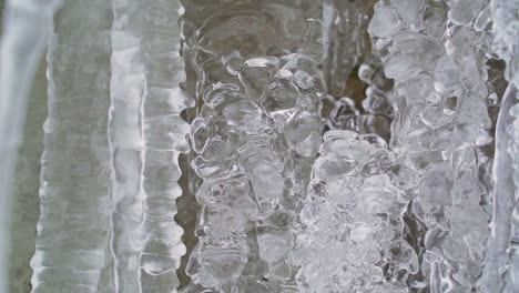 crystal clear icicles at waterfall in winter, close up panning shot