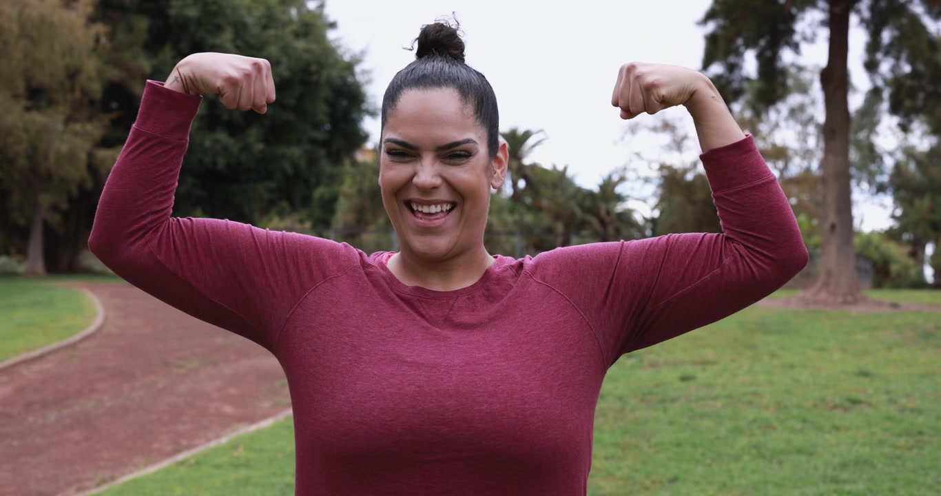Happy Woman Flexing Muscles in Public Park
