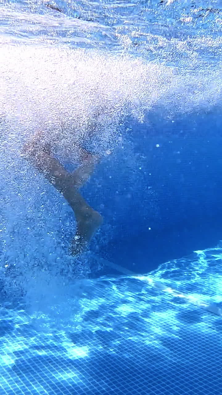 Person Diving Underwater in Swimming Pool