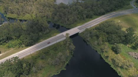 Cinematic-drone-clip-of-the-Lakeshore-road-bridge-over-the-canal-that-connects-Lake-Minnehaha-to-Lake-Susan-in-Clermont,-FL