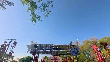 a vibrant bridge adorned with flowers under clear skies in bangkok's rama ix park, showcasing serene natural beauty