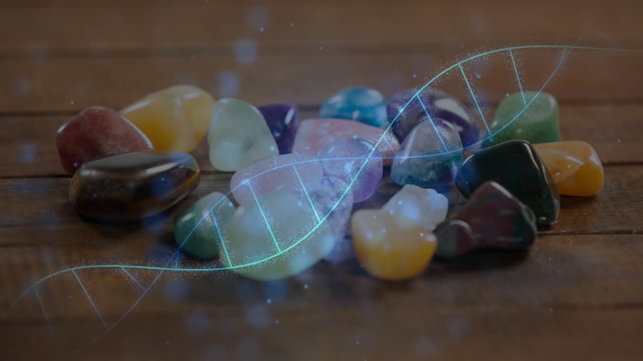 Tumbled gemstones being visualized close-up on wooden tabletop, featuring glowing DNA helix overlay