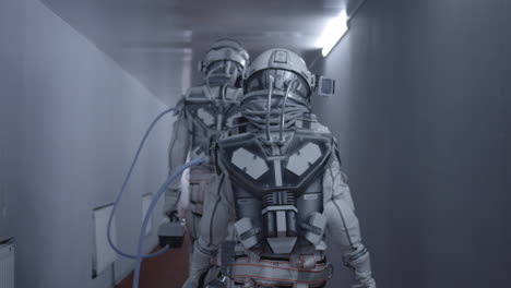 astronauts walking through a futuristic corridor