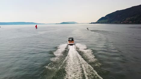 Drohnenaufnahmen-Aus-Der-Luft,-Die-Motorbooten-Auf-Dem-Bielersee-Folgen-Und-Das-Blaue-Wasser-Und-Die-Wunderschöne-Landschaft-Zeigen