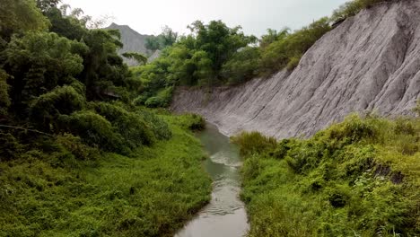 Aerial-flyover-idyllic-river-in-Tianliao-Moon-World-during-sunny-day,-Taiwan