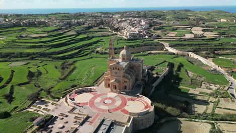 drone video flying left, circling around the basilica of the national shrine of the blessed virgin of ta' pinu in gozo, malta