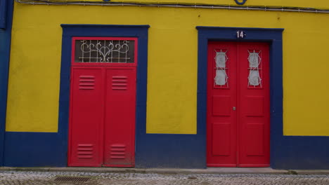 yellow building with red doors in aveiro, portugal. static shot
