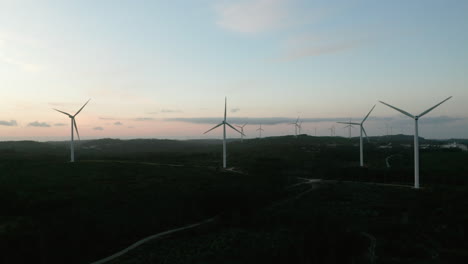 Paisaje-Natural-Escénico-Con-Hélice-Giratoria-De-Turbinas-Eólicas-Durante-La-Puesta-De-Sol-En-Serra-De-Aire-E-Candeeiros,-Leiria-Portugal