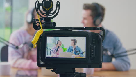 View-Through-Camera-Of-Couple-Wearing-Headphones-Vlogging-Live-Streaming-Laughing-And-Talking