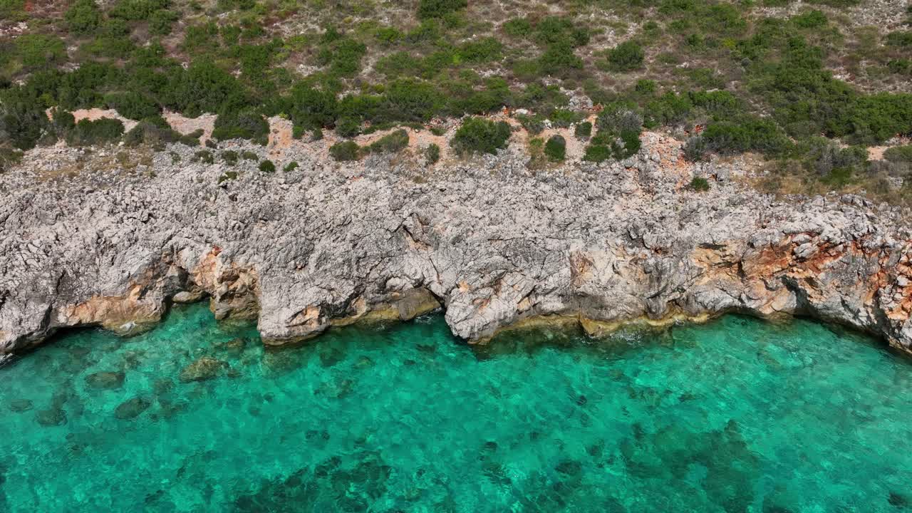 Coastal cliffs and green landscape at Gjipe, Albania, aerial pull-out