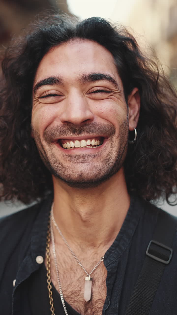 retrato de un hombre sonriente con el cabello rizado