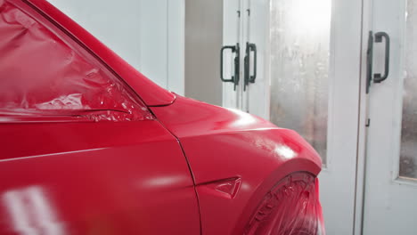 coche eléctrico rojo en la cabina de pintura