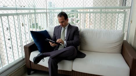 man in a suit and tie working with his tablet. making negative faces and gestures.