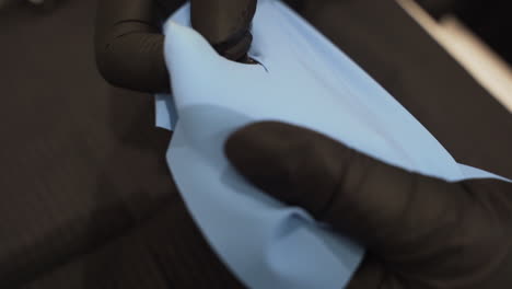 inserting clamp on dental rubber dam - high angle close up