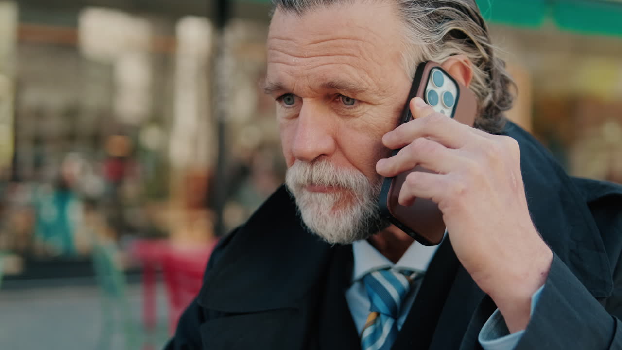 Smiling Businessman Talks On Phone At Cafe