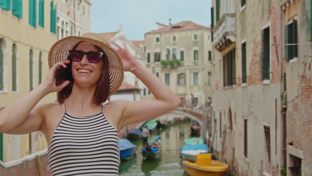 Turista donna che parla al cellulare vicino a un canale
