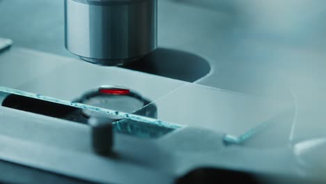 examining blood specimen on glass slide under microscope