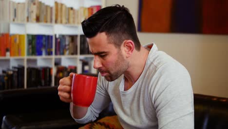 man using digital tablet while having coffee