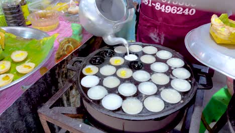 cocinando panqueques tailandeses tradicionales en un mercado