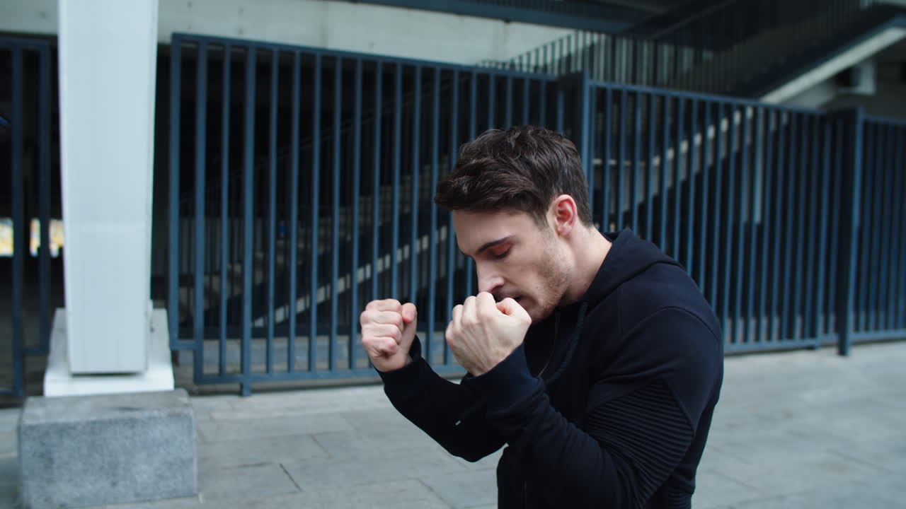 클로즈업 잘생긴 남자가 야외에서 비트를 연습하고 있습니다. 젊은 남자가 권투  ⁇ 치를 연습하고 있습니다.