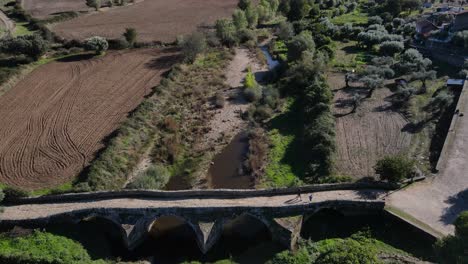 Drone-flies-past-the-Idanha-a-Velha-Roman-Bridge-showing-the-disappearing-water-behind