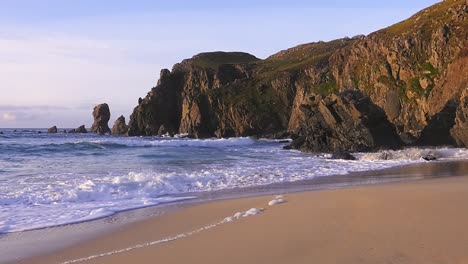 golden hour-aufnahmen der wellen und der landzunge rund um den dalmore beach in der nähe von carloway