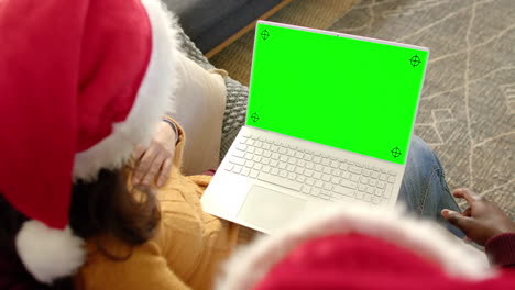 Happy-diverse-couple-having-christmas-laptop-video-call-with-green-screen,-slow-motion