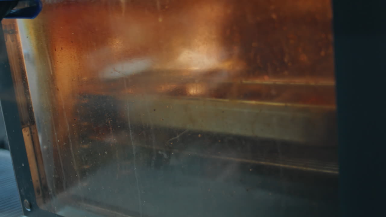 Restaurant worker checking eggplants temperature in professional oven closeup