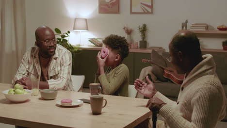 Black-men-and-boy-having-fun-while-eating-at-home