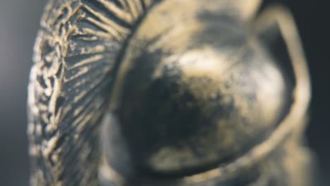 a close up macro detailed tilt down shot of a spartan face design, warrior metal bronze helmet, on a 360 rotating stand, studio lighting, 4k smooth movement