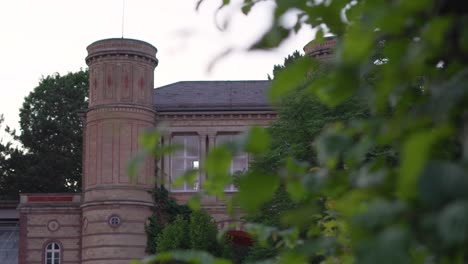 mansion in the evening light with a hedge in the foreground