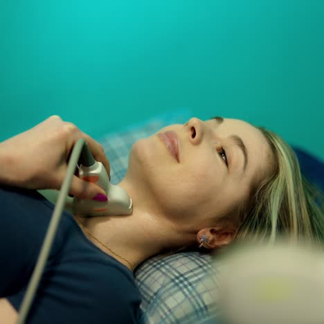 woman doing ultrasound examination. female patient is lying in hospital bed during uzi diagnostic. doctor's hand holding medical sensor while making ultrasound.