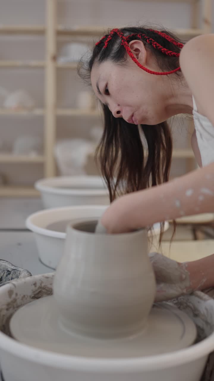 A woman making pottery on a wheel